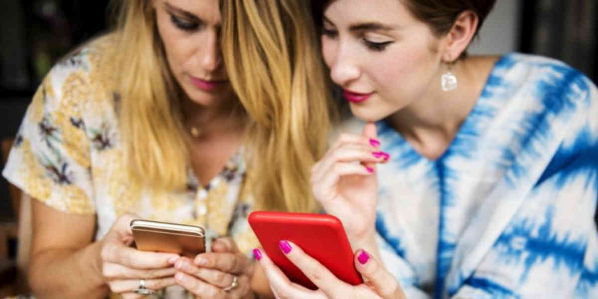 Women viewing mobile phone devices