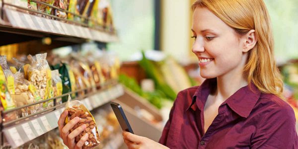 Female Millennial Using Mobile App While Grocery Shopping
